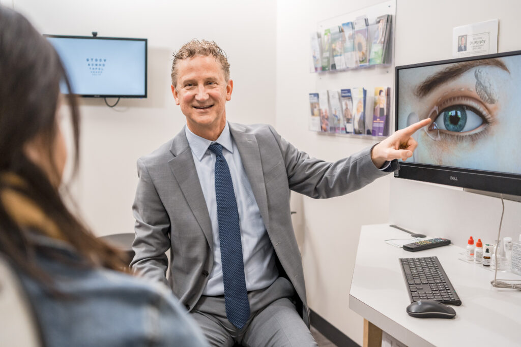 Ophthalmic plastic surgeon Dr. Michael Murphy in an exam room showing a patient the lacrimal system on computer screen